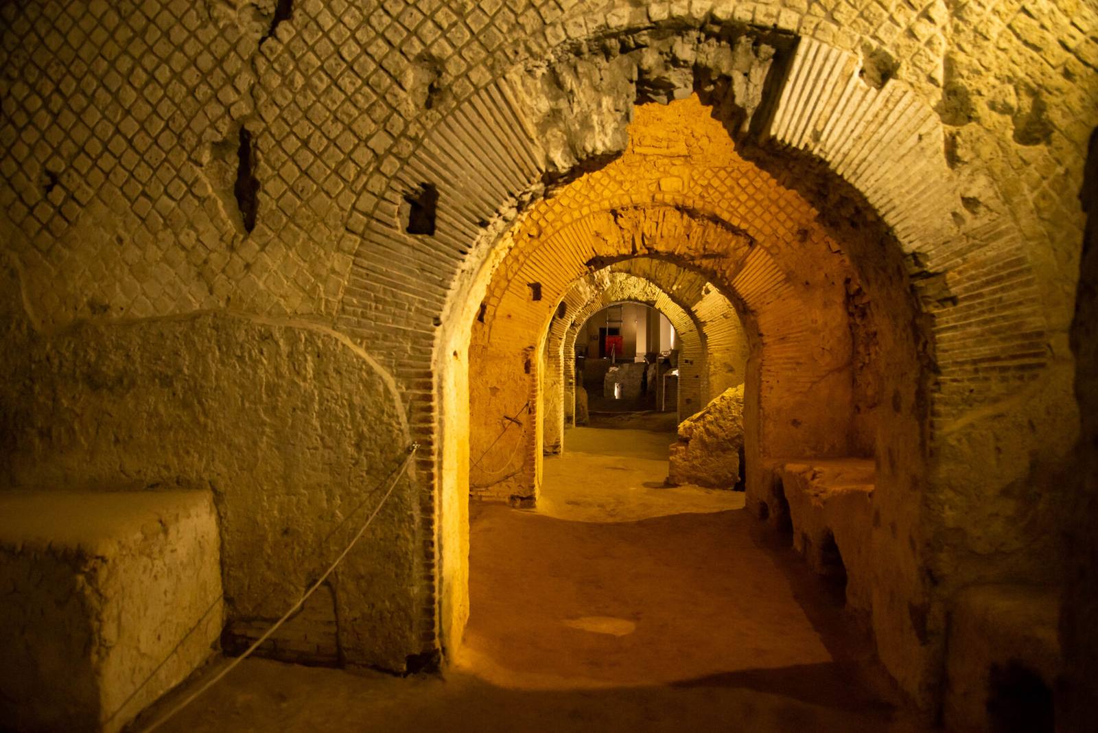Tunnel sotterraneo di Napoli illuminato da luci calde