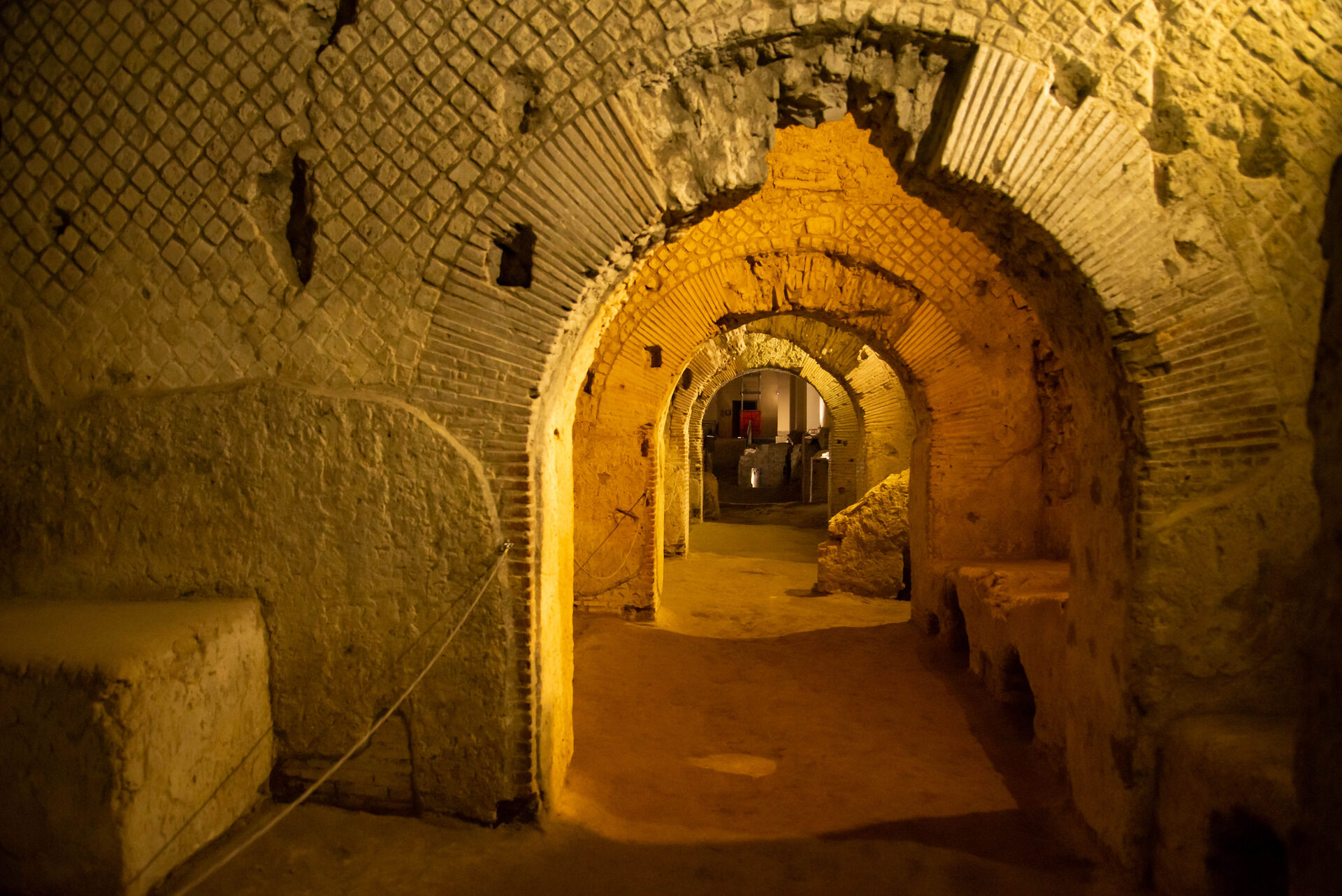 Tunnel sotterraneo di Napoli illuminato da luci calde